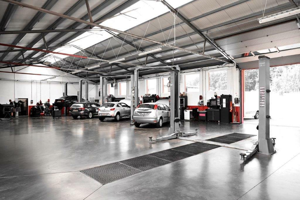 Innenaufnahme der Autowerkstatt Ackermann, einem breit aufgestellten KFZ-Fachbetrieb in Merenberg-Allendorf, mit mehreren Fahrzeugen auf Hebebühnen, professionellem Equipment und sauberer Werkstattumgebung, der Werkstattservice, Lackiererei, Unfallinstandsetzung und mehr unter einem Dach vereint.