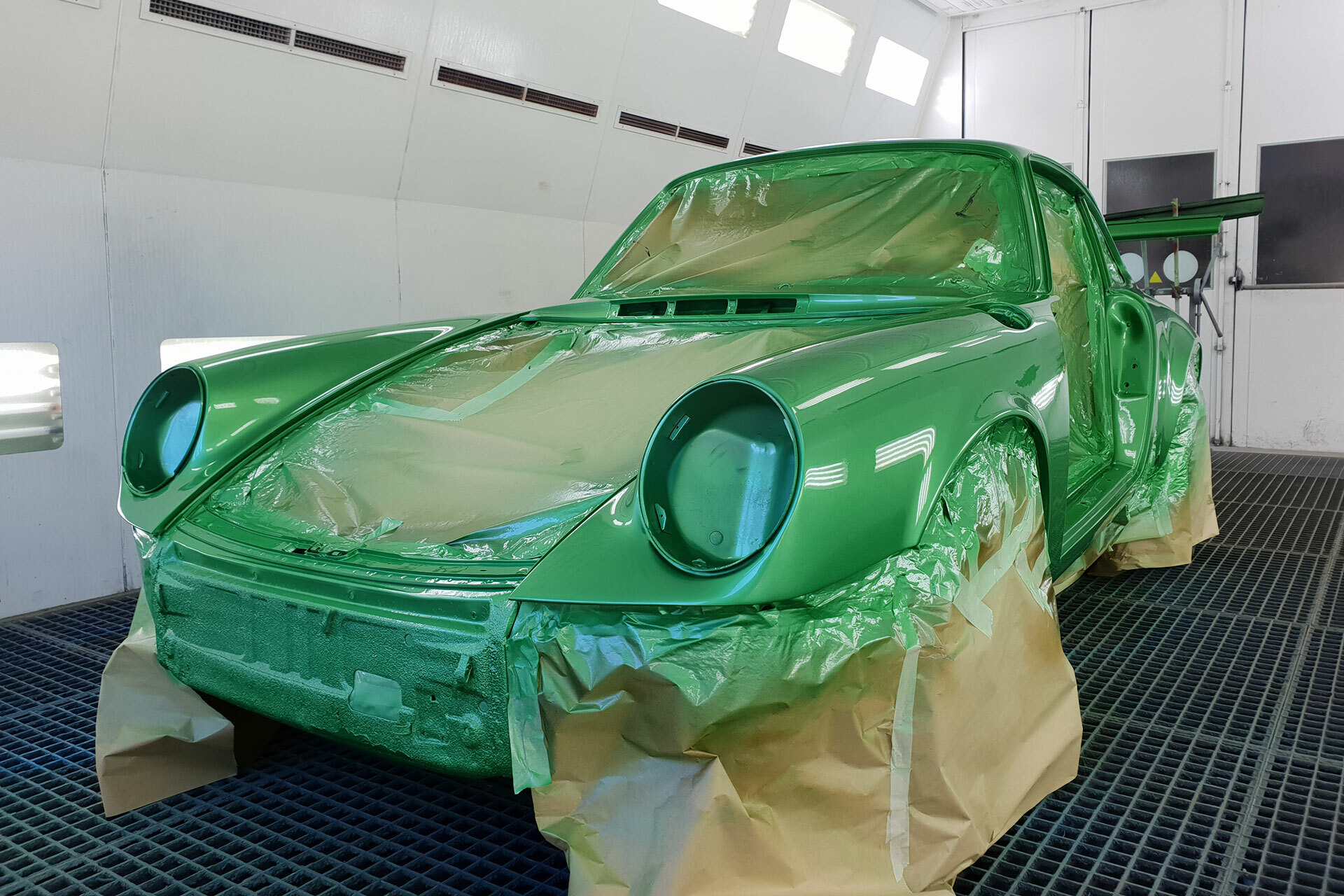 Grünes Lackieren eines klassischen Porsche 911 in der Lackierkabine der Autowerkstatt Ackermann – Fachbetrieb für Werkstattservice, Unfallinstandsetzung und Young-Oldtimer.