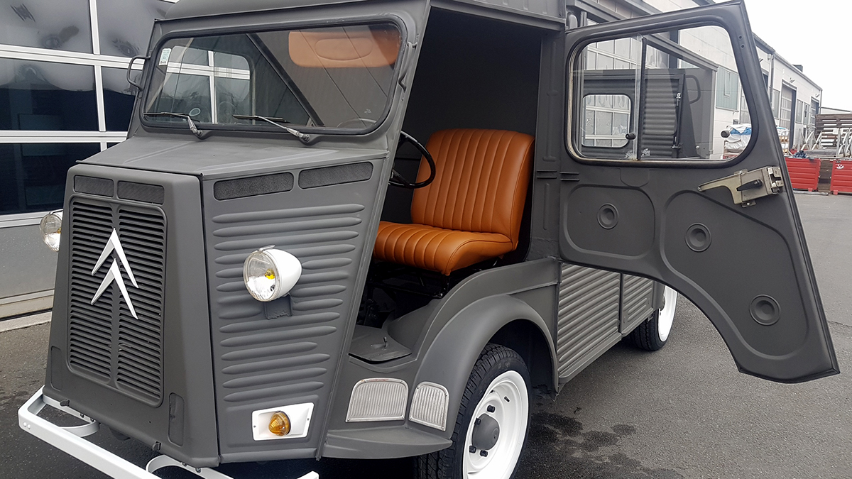 Grauer klassischer Citroën mit braunem Leder-Sitz und geöffneter Fahrertür, repräsentativ für die fachgerechte Betreuung von Oldtimern bei Autowerkstatt Ackermann.